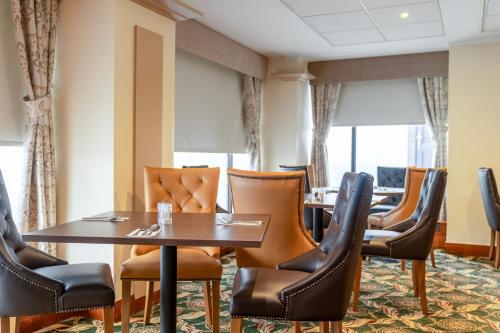 a dining room with tables and leather chairs at Grand Hotel Blackpool in Blackpool