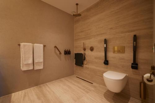 a bathroom with a toilet and towels on the wall at Hotel Thermen Berendonck in Nijmegen