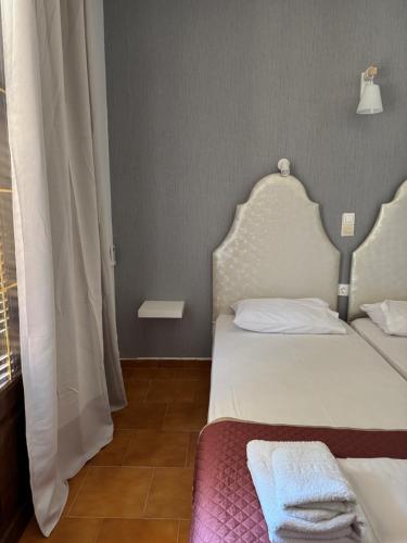 a small bedroom with two beds and a window at Kassiopi Apartmets4you III in Kassiopi