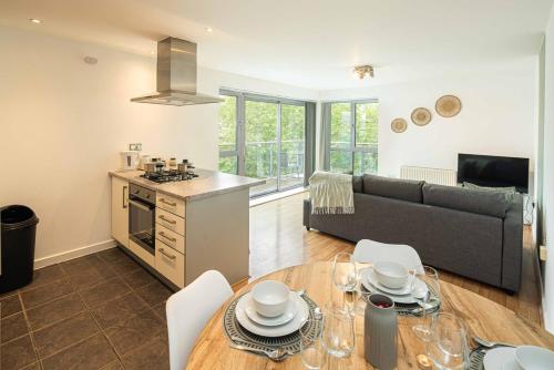 a kitchen and living room with a table and a couch at Stylish 2-Bed with Stunning View in London