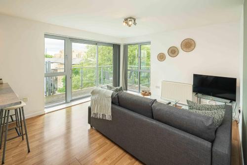 a living room with a couch and a television at Stylish 2-Bed with Stunning View in London