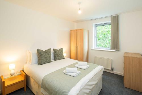 a bedroom with a large white bed with a window at Stylish 2-Bed with Stunning View in London