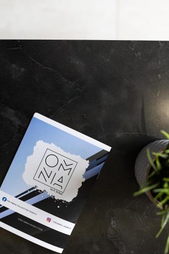 a book sitting on a table next to a plant at The Omnia Collection Pagrati in Athens