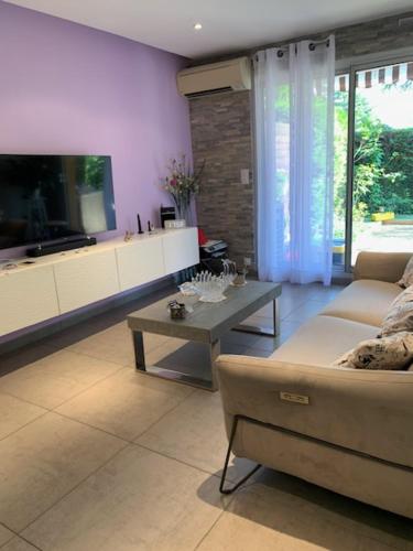 un salon avec un canapé et une table dans l'établissement Centre Capitou avec jardin et piscine, à Mandelieu-la-Napoule