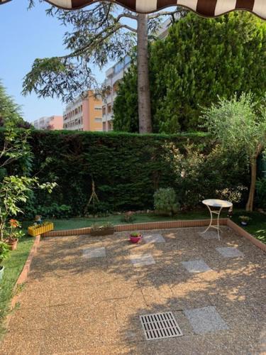 une terrasse avec une table, un parasol et une chaise dans l'établissement Centre Capitou avec jardin et piscine, à Mandelieu-la-Napoule