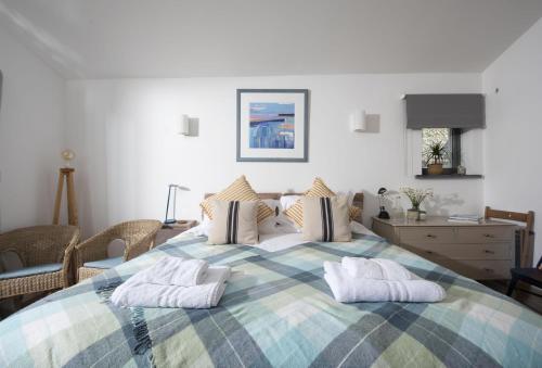 a bedroom with a large bed with two pillows on it at The Perch Studio in Polzeath