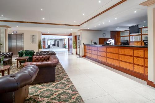 a lobby with leather couches and a bar at Grand Hotel Blackpool in Blackpool