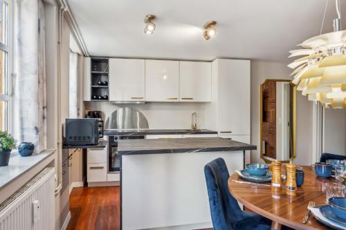 a kitchen with a wooden table and a dining room at Prime Location - Near Nyhavn & Tivoli Gardens in Copenhagen