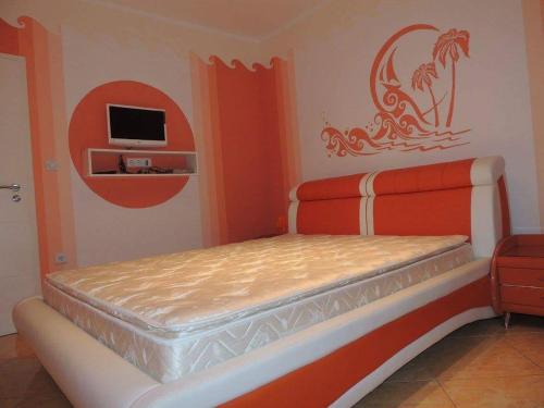 a bedroom with a bed with a tv on the wall at Apartmani Niksic in Herceg-Novi