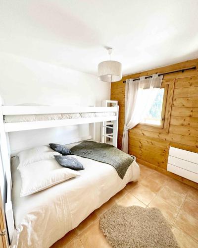 une chambre avec un lit superposé et une fenêtre dans l'établissement L'Ourson aux pieds des pistes & piscine chauffée, à Crest-Voland