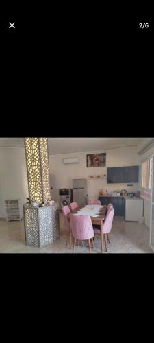 a living room with a table and chairs and a kitchen at Arous jabal in Ksar es Sghir