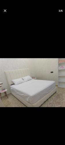 a bedroom with a white bed and a table at Arous jabal in Ksar es Sghir
