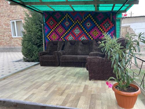 a couch sitting on a patio with a painting at Center guesthouse in Kochkor
