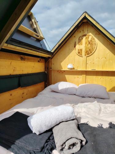 - une chambre avec un lit dans une maison en bois dans l'établissement La Tiny House de l'Ouchette, à Brégy