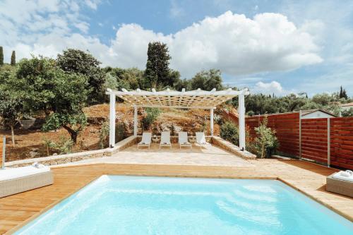a swimming pool in a backyard with a pergola at Moute House by Corfuescapes in Ágioi Doúloi