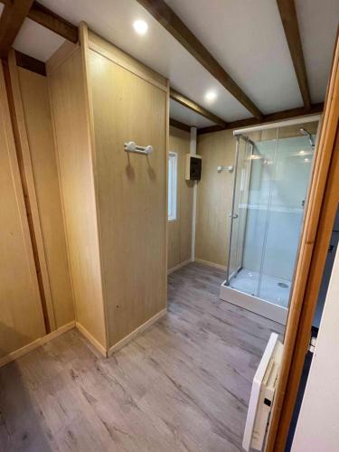 une pièce vide avec une douche et une porte en verre dans l'établissement Camping le Convivial Cottage climatisé 6-8 personnes, à Saint-Martial-de-Nabirat