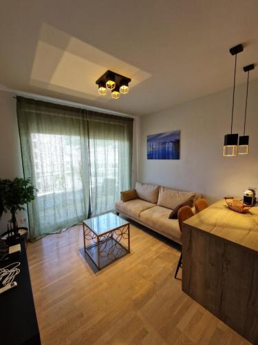 ein Wohnzimmer mit Sofa und Tisch in der Unterkunft Apartment ENJOY in Bar