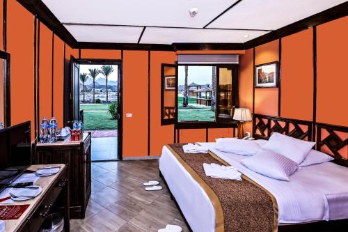 a bedroom with a large bed with orange walls at Xperience Golden Sandy Beach in Sharm El Sheikh