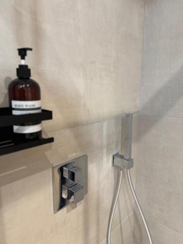 a bottle of soap is sitting on a shelf in a bathroom at Mountain Lodge in San Lorenzo in Banale