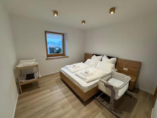 a bedroom with a bed with a chair and a window at Mountain Lodge in San Lorenzo in Banale