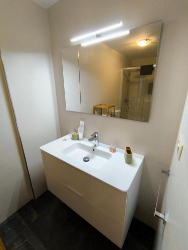 a bathroom with a white sink and a mirror at Piso en primera linea de Playa en Laxe in Laxe