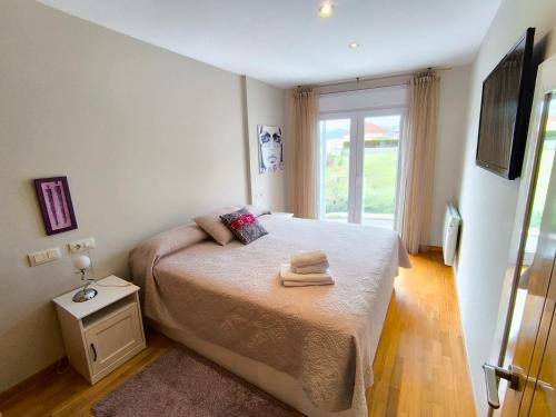 a bedroom with a bed with two towels on it at Piso en primera linea de Playa en Laxe in Laxe