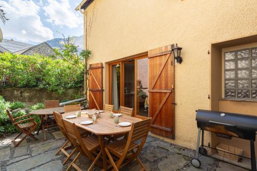 - une table et des chaises en bois sur une terrasse avec barbecue dans l'établissement La Petite Maison des Montagnes, à Luz-Saint-Sauveur