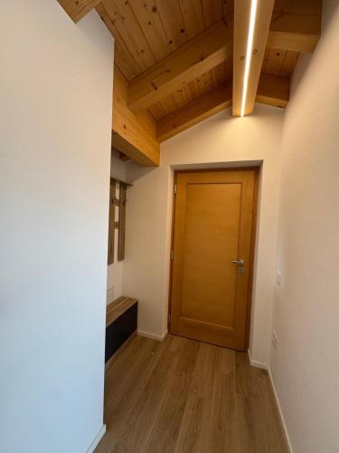 a hallway with a wooden door and wooden floors at Mountain Lodge in San Lorenzo in Banale