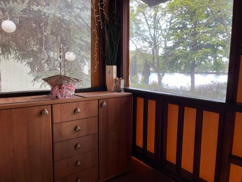 a dresser in a room with a large window at Szitakötő Békésszentandrás Vendégház in Békésszentandrás
