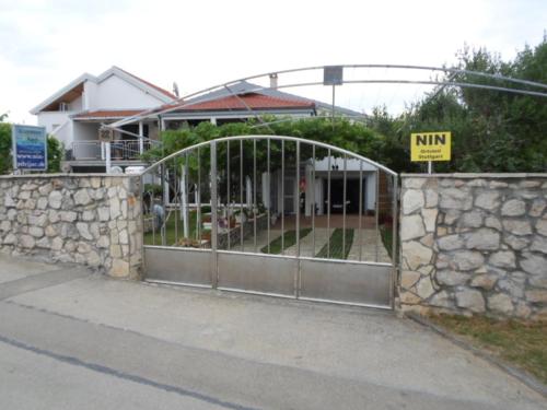 a gate in front of a house with a stone wall at Kata in Nin
