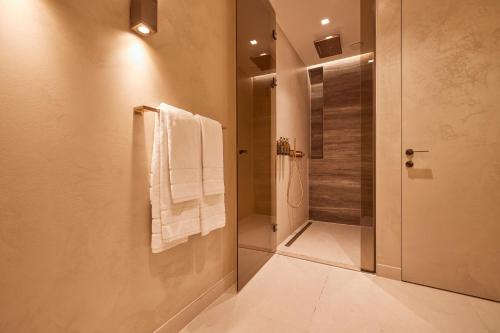 a bathroom with a shower with white towels on a wall at Hotel Thermen Berendonck in Nijmegen