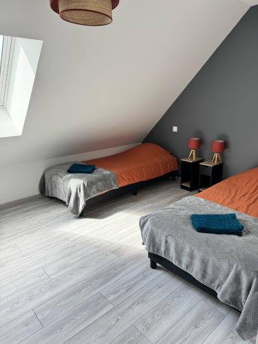 - une chambre mansardée avec 2 lits et 2 tables dans l'établissement Maison des Laquais, à Saint-Laurent-sur-Mer