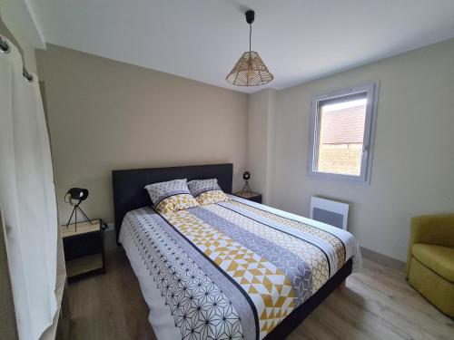 a bedroom with a bed and a window at Le Séchoir des acacias, Gîte La Noyeraie in Saint-Léon-sur-Vézère
