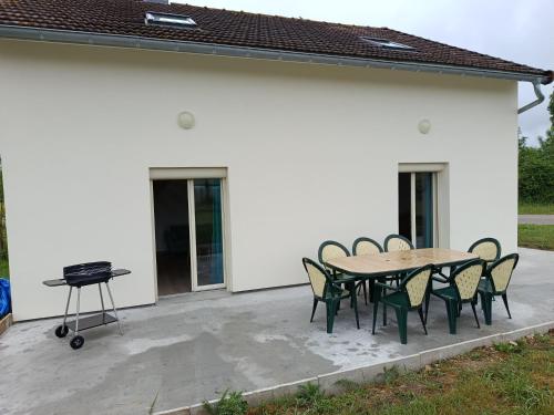 a patio with a table and chairs and a grill at Maison de campagne in Souvans