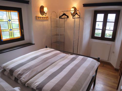 a bedroom with a bed in a room with a window at Ferienwohnungen Haus Hinneres in Schalkenmehren