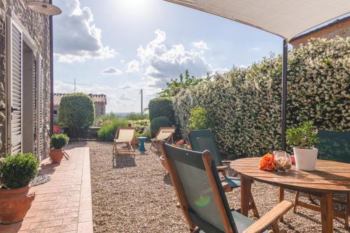 an outdoor patio with a wooden table and chairs at Borgo La Fonte - Together in Tuscany in Cortona