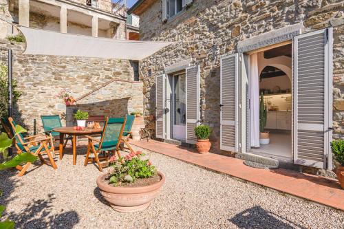 a patio with a table and chairs and a building at Borgo La Fonte - Together in Tuscany in Cortona
