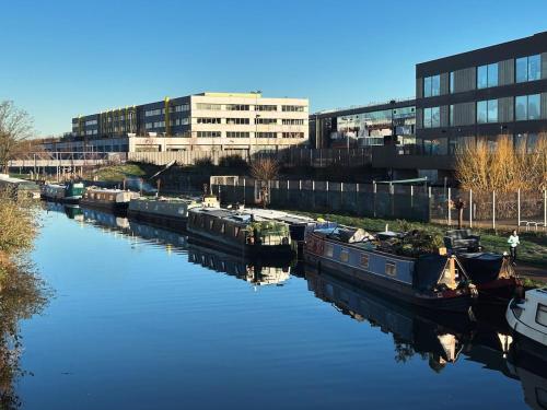 a group of boats docked in a river with a building at The Floating Terrarium in London
