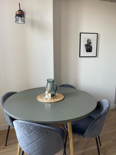 une table avec des chaises bleues et un vase au-dessus dans l'établissement Duplex Place Garibaldi - Close to port, Old Nice, à Nice