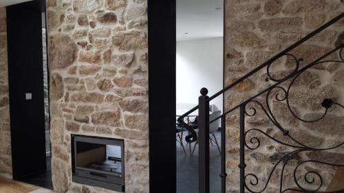 a stone wall with a fireplace in a house at Casas de Campo da Barroca in Tabosa