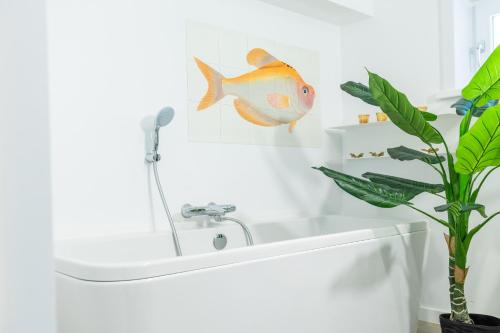 a bathroom with a fish on the wall next to a sink at Zeesamen 5 min from beach in Cadzand