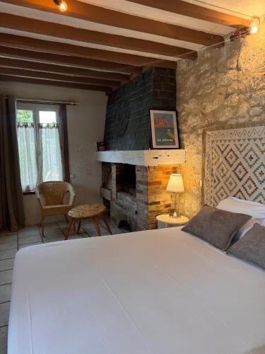 a bedroom with a bed and a stone fireplace at Motel - Usine à Gaz in Bourgueil