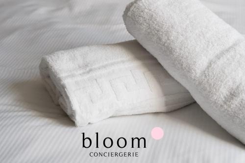 a roll of white towels on a bed at Appartement de Standing Neuf in Nancy