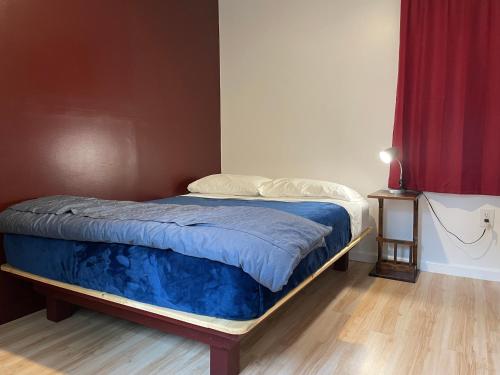 a bed in a room with a red curtain at Talkeetna Wilderness Lodge & Cabin Rentals in Sunshine