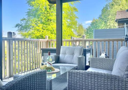 a patio with chairs and a table on a porch at Dolphin Run in Hunters Quay