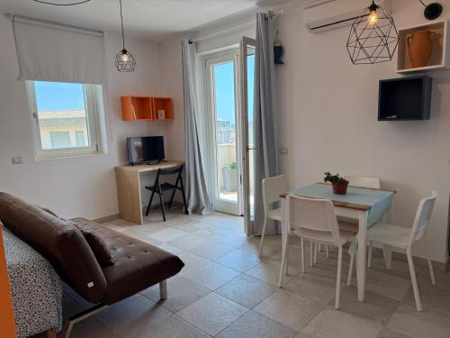 a living room with a table and a dining room at Donnalucata Ospitalità Diffusa in Donnalucata