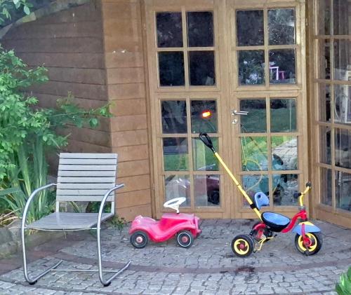 two toy cars and a chair next to a house at Ferienwohnung Weserperle in Nordenham