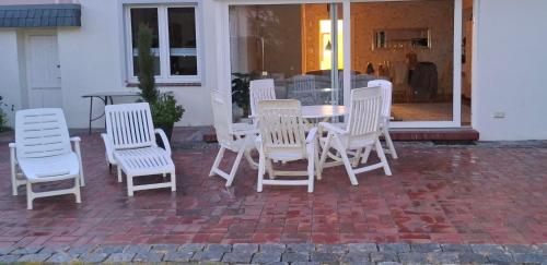 a group of white chairs and a table on a patio at Ferienwohnung Weserperle in Nordenham