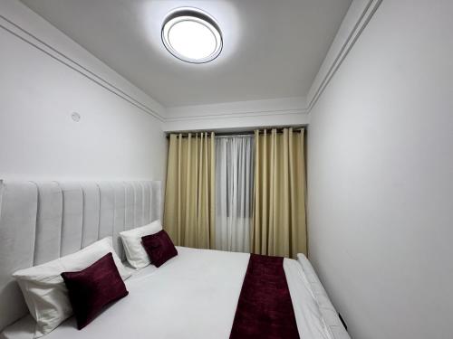 a bedroom with a white bed and a window at Lovely one bedroom in Kilimani near yaya centre in Nairobi