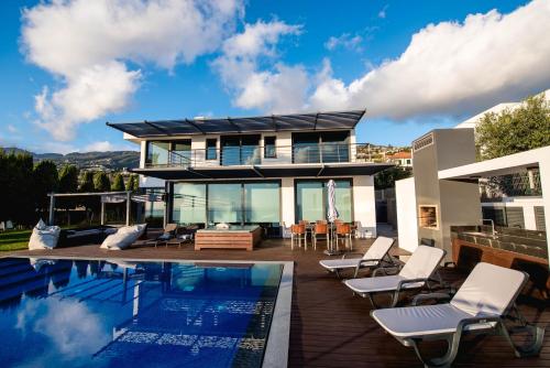 a house with a swimming pool and some chairs at Villa Cary in Funchal